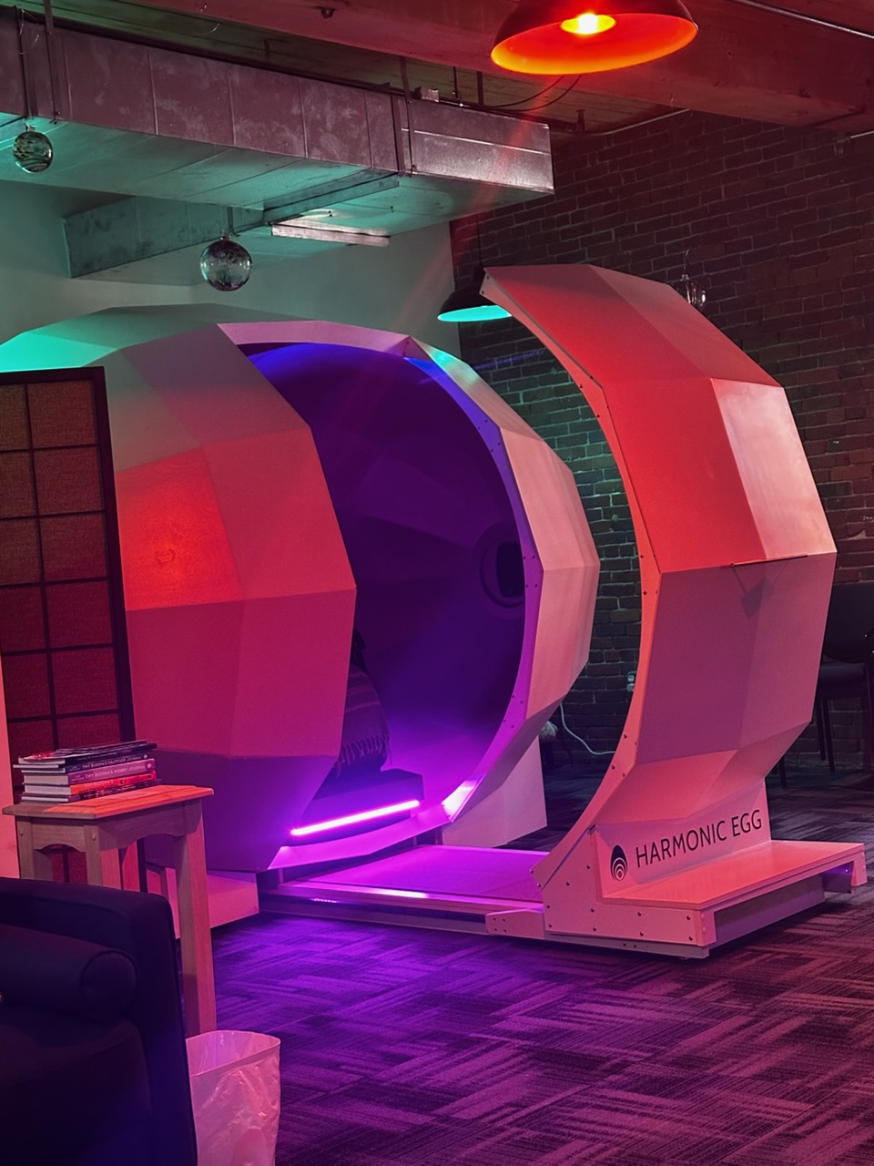 The Harmonic Egg opening with warm pink and violet lighting